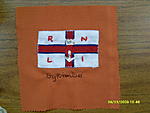Square made for bykimbo - RNLI Flag / standard set on orange cotton square. The flag is white satin padded, with navy and red satin ribbons criss...