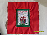 Christmas present cross stitch square bordered in green and backed with a red polycotton square. Won in YDC 68 by Helpingways